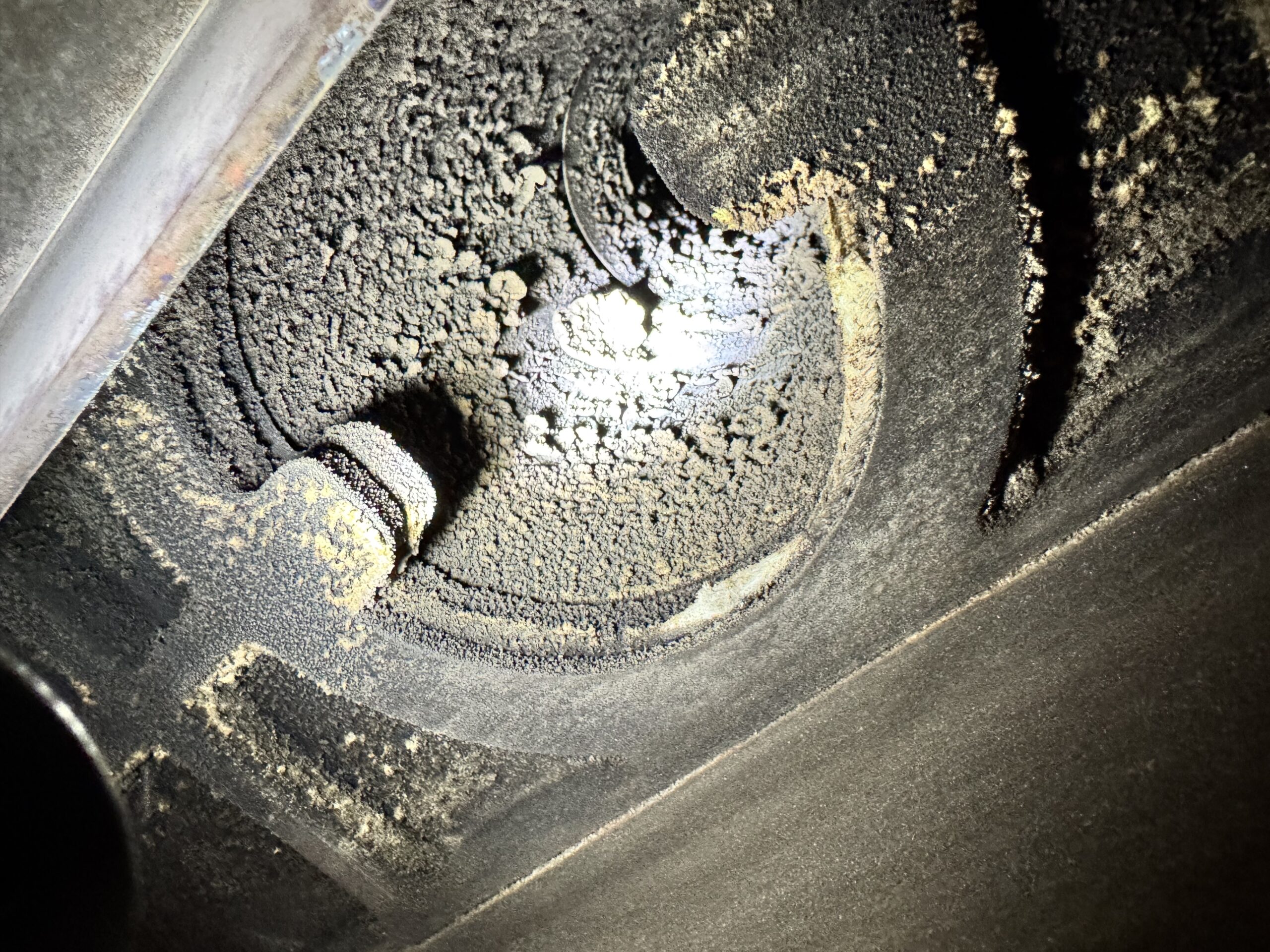 Soot deposits inside a log burner flue pipe before chimney sweeping